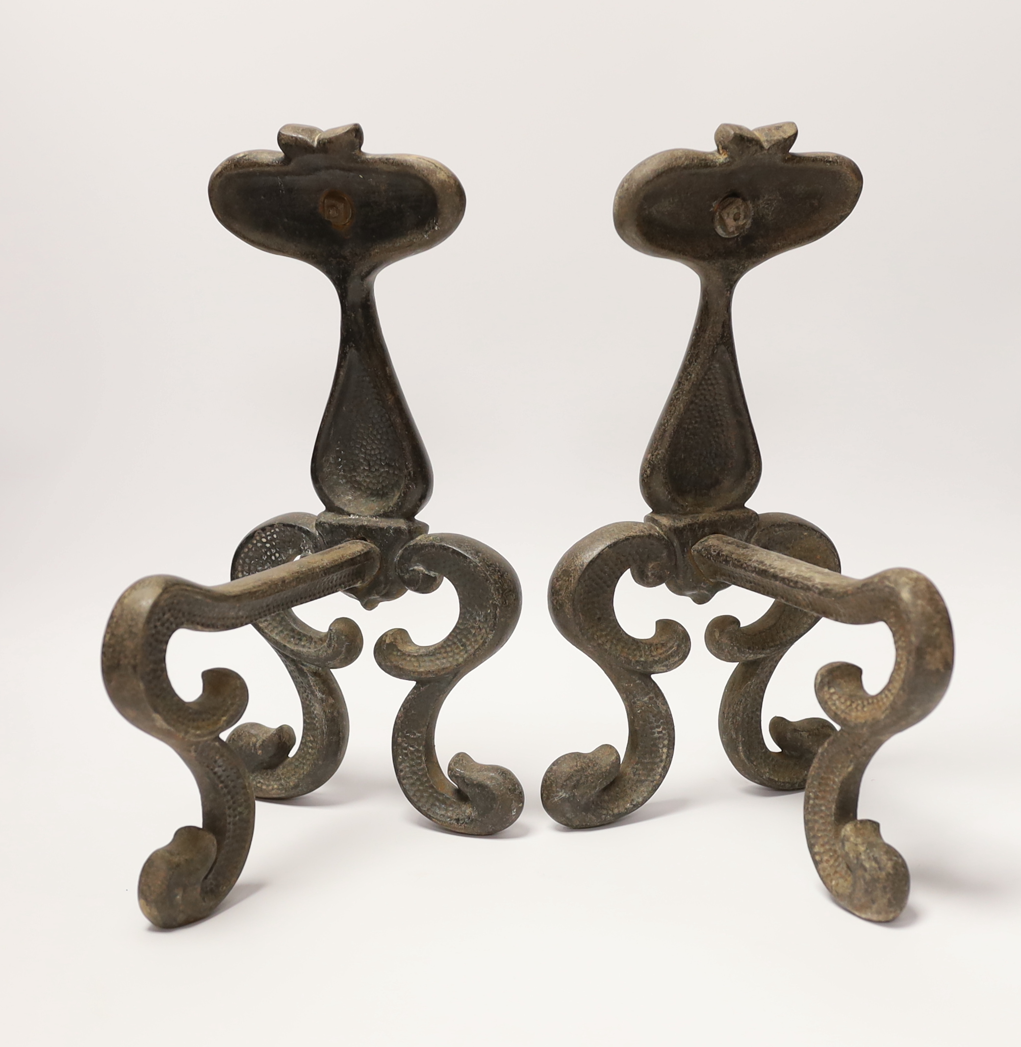 A pair of Art Nouveau cast iron and embossed copper fire dogs, 33cm high